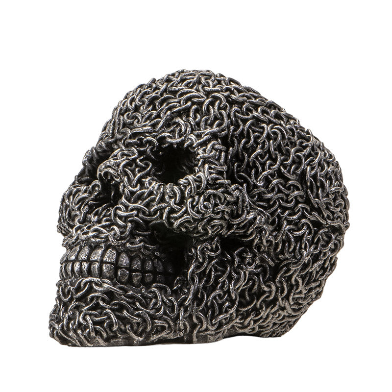 Side profile of gothic skull statue with chain wrapped design and textured finish