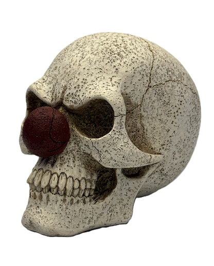 Front left view of creepy clown skull statue with red nose cracked bone texture and detailed teeth gothic decor

