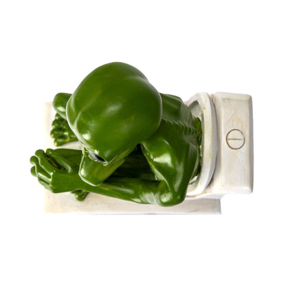 Top view of alien head and posture while sitting on toilet
