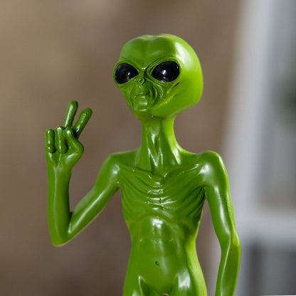 Close up of alien face with large black eyes and green finish
