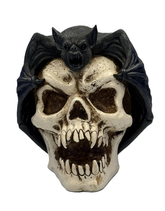 Front view of gothic bat perched on skull statue with wings spread and distressed bone detailing
