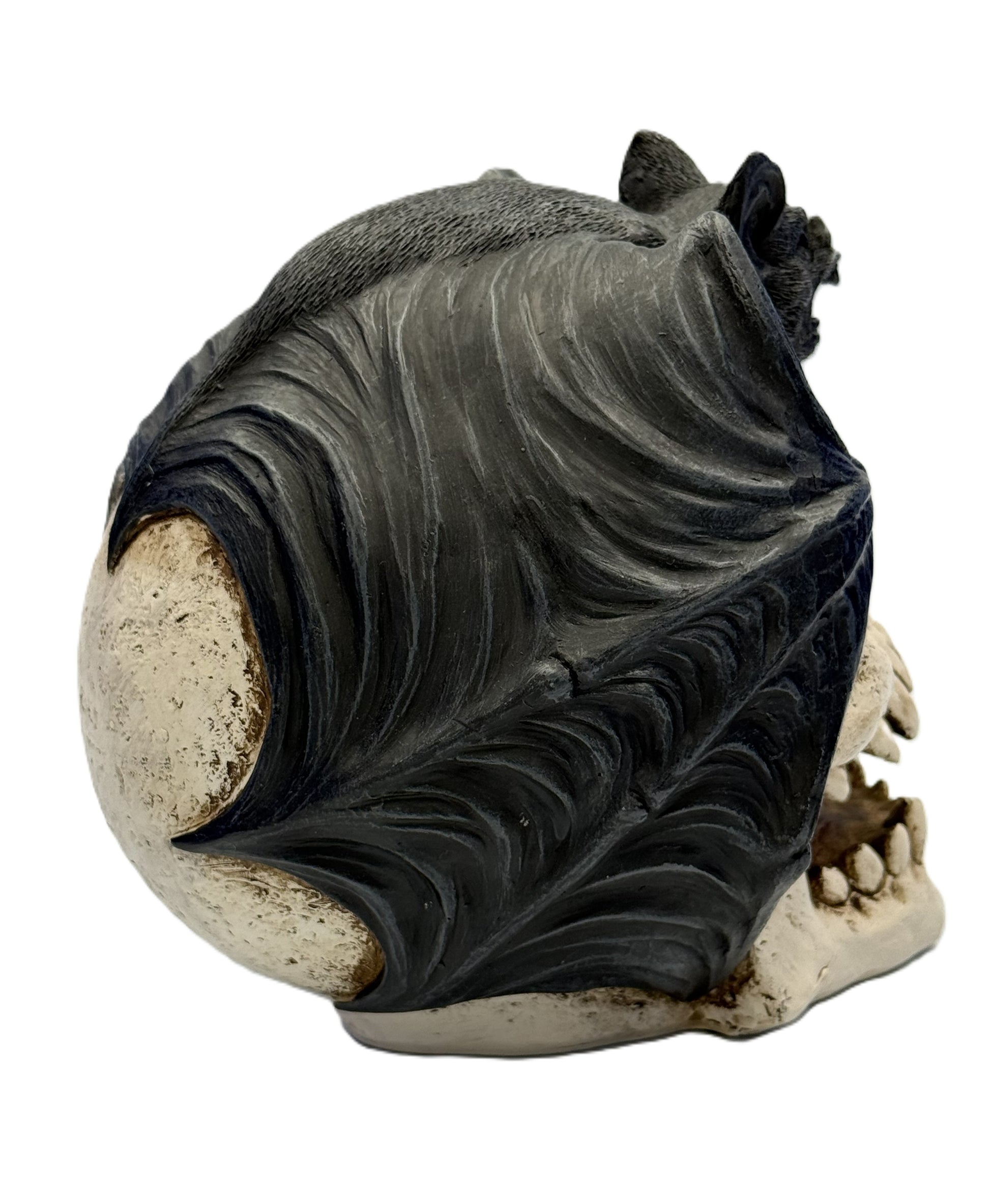 Rear angled view of gothic bat sculpture wrapped around skull with dramatic wing design
