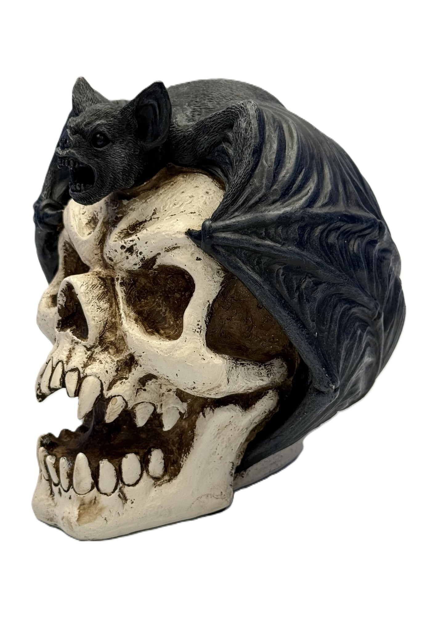 Side view of bat skull figurine showing textured wings wrapped around skull and detailed fangs

