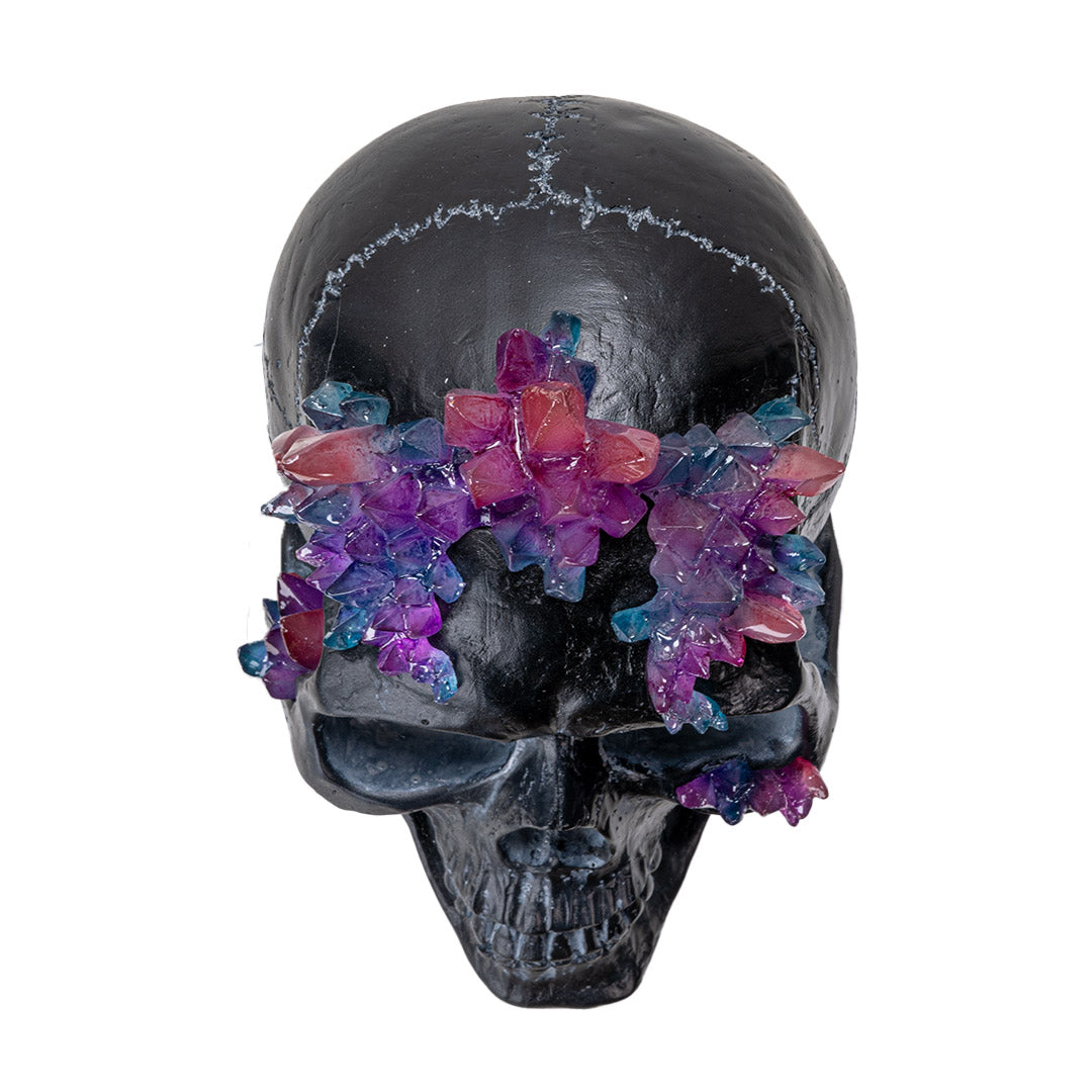 Top view of skull with vibrant purple pink and blue crystal clusters
