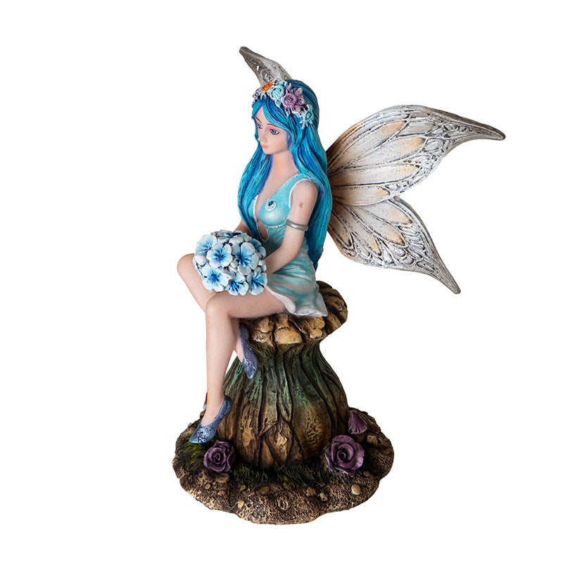 Side view of fairy figurine on mushroom with detailed wings and textured base
