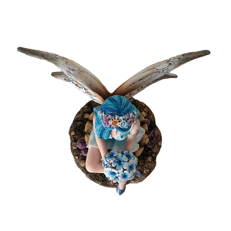 Top view of fairy on mushroom figurine highlighting floral bouquet and pose
