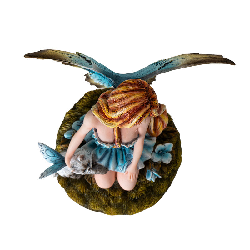 Top view of fairy statue with cat highlighting wings and floral base details
