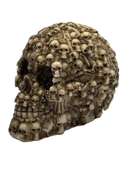 Front angled view of boneyard skull statue covered in dozens of miniature skulls and bones in gothic resin finish
