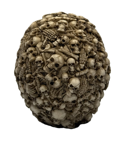 Rear view of multi skull statue showing dense arrangement of bones and skulls in textured gothic design
