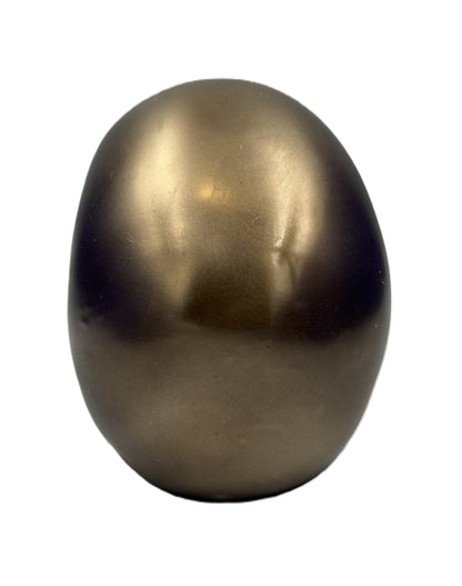 Back view of skull sculpture highlighting smooth rounded surface and bronze finish
