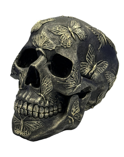 Angled left view of butterfly skull decor showing intricate butterfly wing carvings and textured finish

