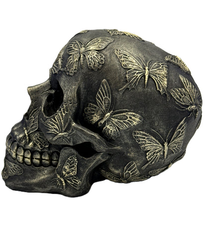 Right side view of decorative skull with raised butterfly details and dark antique finish
