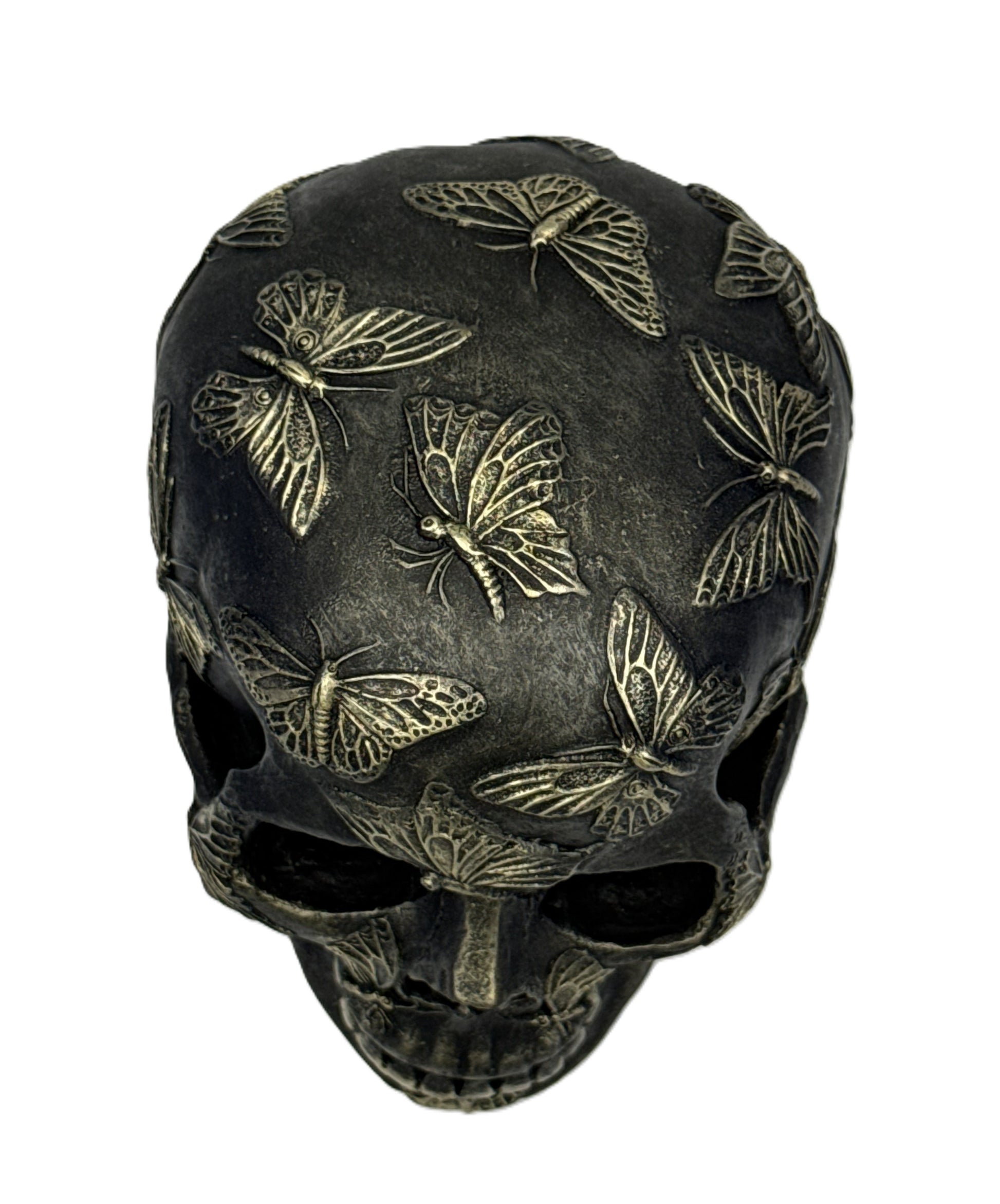 Top view of skull sculpture showing dense butterfly designs across the crown and upper surface
