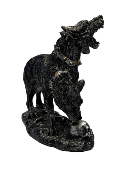 Front right angled view of Cerberus sculpture with snarling heads open jaws and skull detail on base
