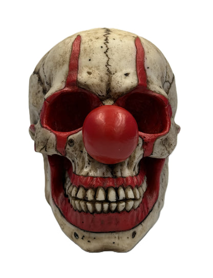 Front view of creepy clown skull statue with red nose hollow eyes and detailed teeth horror collectible

