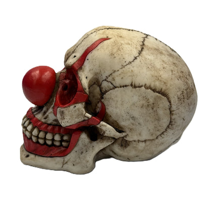 Side view of horror clown skull figurine showing cracked bone texture and red painted facial accents
