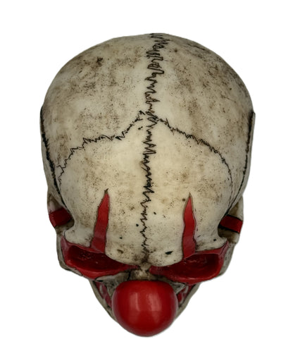 Top view of clown skull statue showing stitched design across skull and weathered antique finish
