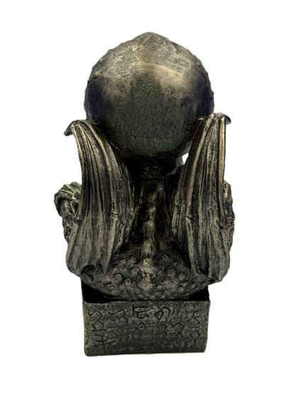 Back view of Cthulhu statue with wings extended textured surface and engraved base details
