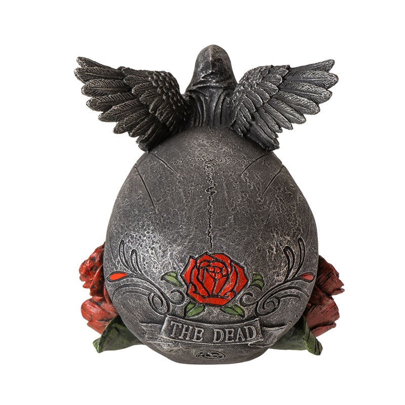 Back view of gothic skull statue showing wings and rose detailing with text the dead
