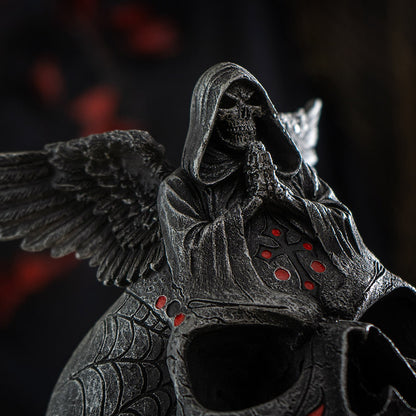 Close up of grim reaper figure on skull with detailed wings and gothic textures
