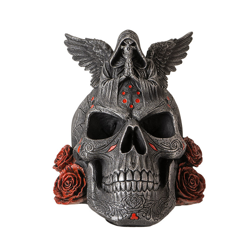 Front view of winged skull statue with grim reaper figure and red accents
