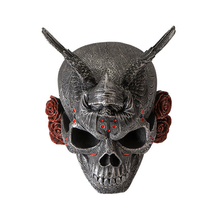 Top view of skull statue with wings and grim reaper figure in prayer position
