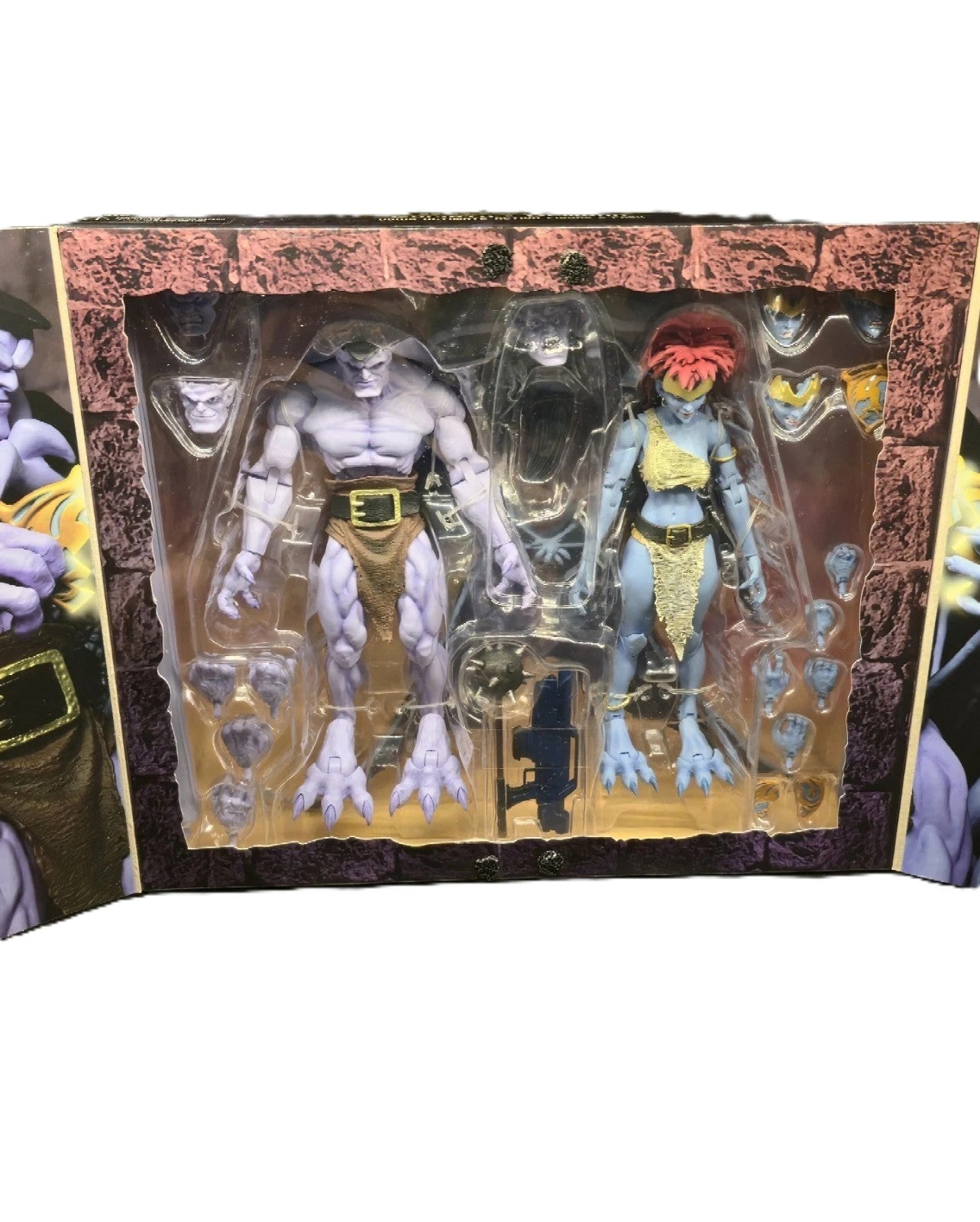 Close Up of opened display packaging for Disney Gargoyles Goliath and Demona Ultimate action figure set with accessories visible
