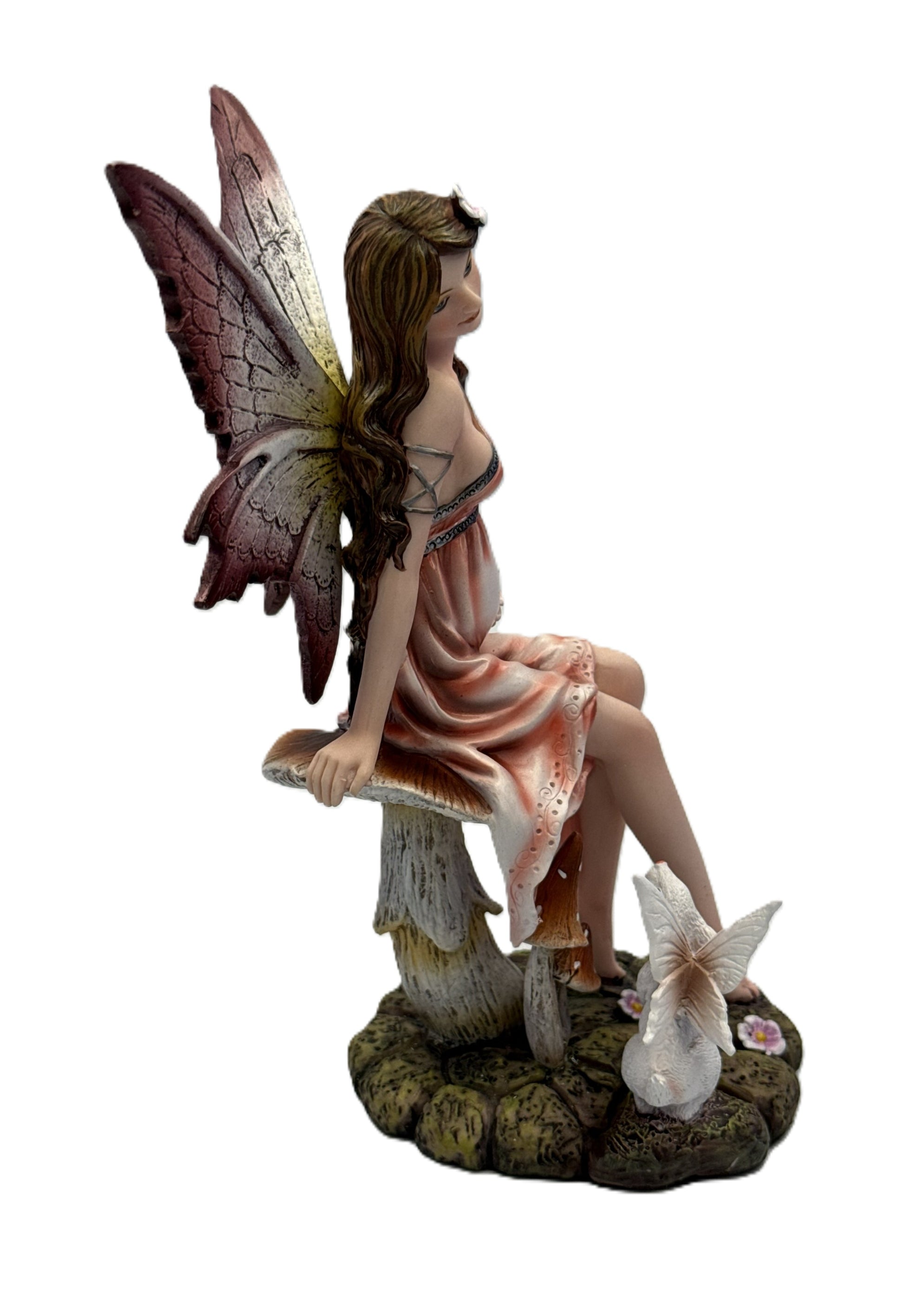Angled view of expecting fairy decor featuring soft pastel dress butterfly wings and nature themed base
