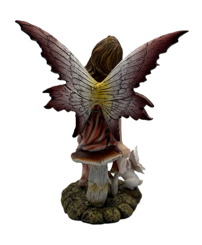 Back view of fairy statue highlighting large textured wings and woodland base with rabbit figure

