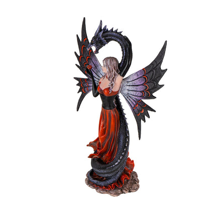 Side view of gothic fairy and dragon sculpture showing flowing dress and dragon tail
