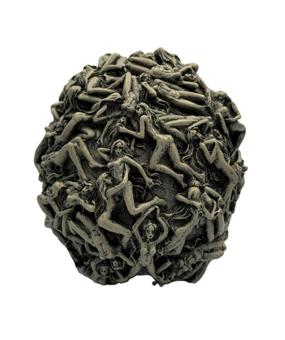 Back view of skull statue showing dense arrangement of intertwined figures covering the entire surface
