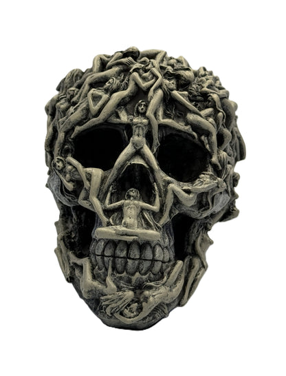 Front view of gothic skull statue covered with intertwined human figures in dark hand-painted resin finish

