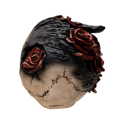 Back view of skull sculpture showing detailed black flame texture and red roses
