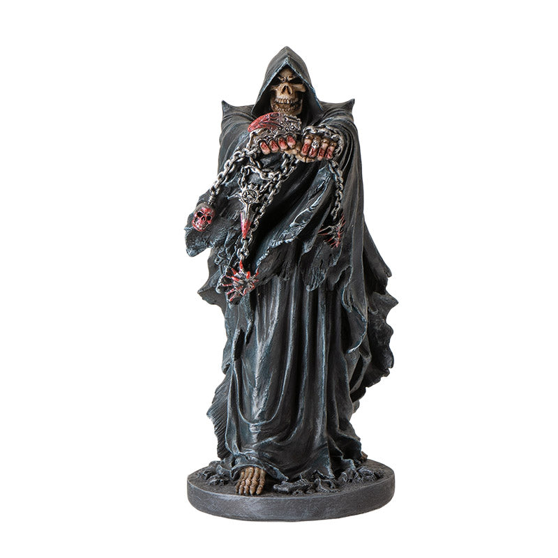 Front view of grim reaper statue holding chains with skull details and gothic cloak
