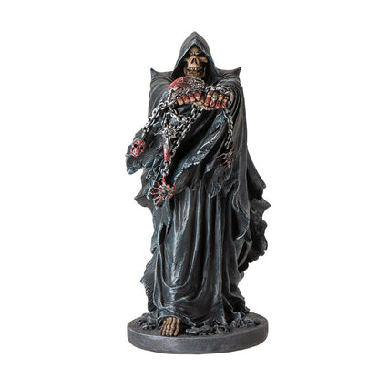 Front view of grim reaper statue holding chains with skull details and gothic cloak
