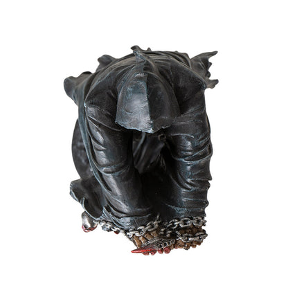 Top view of grim reaper statue showing hood and chained hands detail
