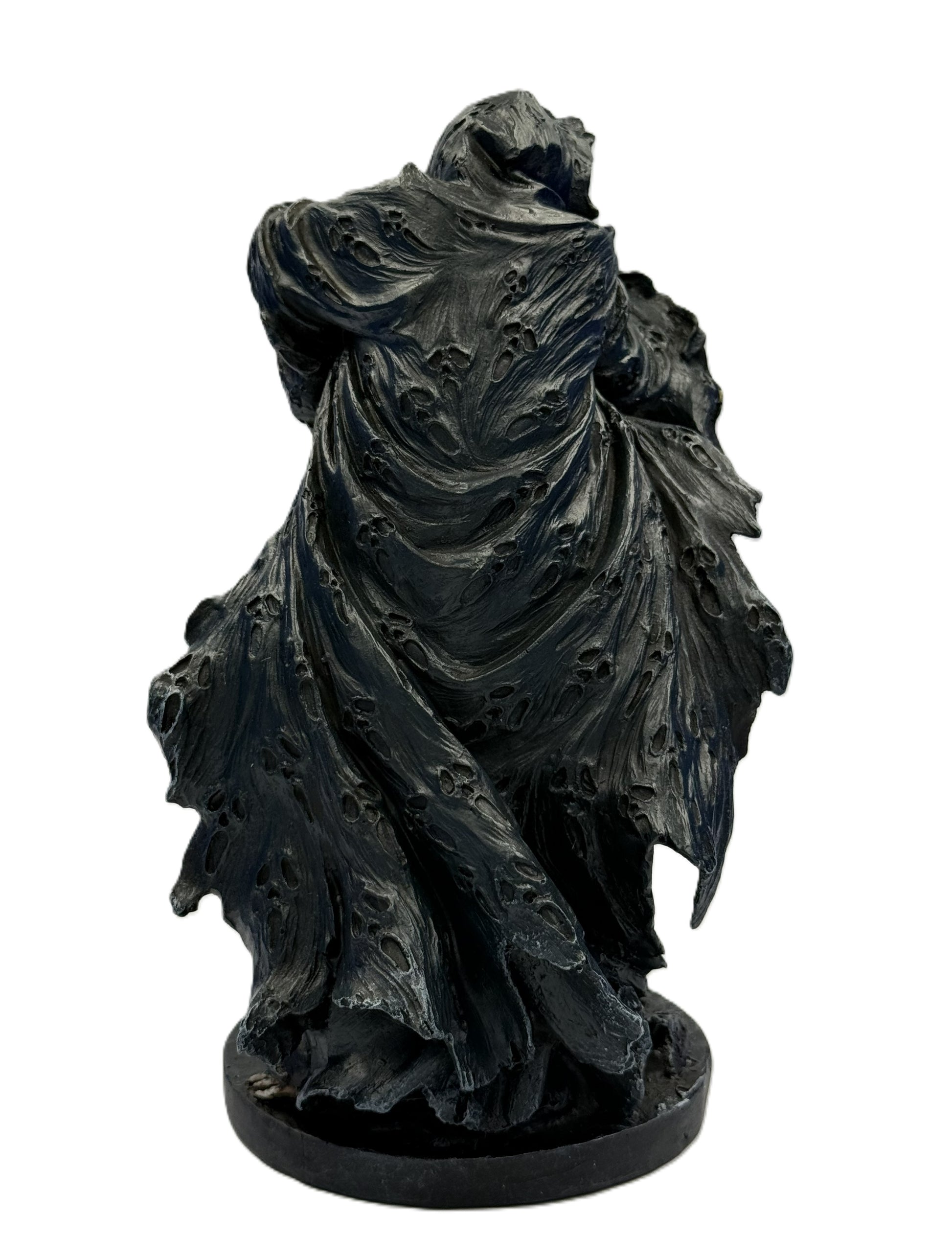 Rear view of grim reaper statue highlighting worn flowing cloak with distressed texture and sculpted movement
