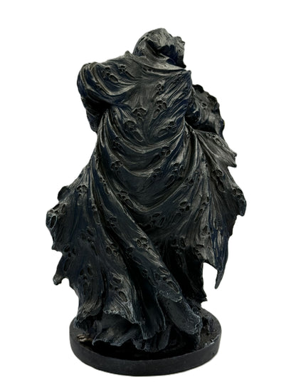 Rear view of grim reaper statue highlighting worn flowing cloak with distressed texture and sculpted movement
