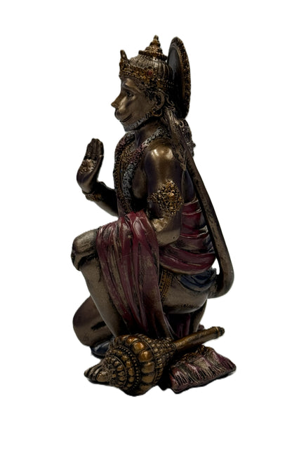 Side profile of Hanuman statue showing detailed ornaments, draped garment, and mace beside figure

