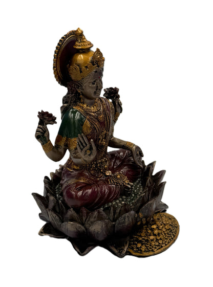 Right angled view of Lakshmi statue with raised blessing hand and lotus flowers in both hands
