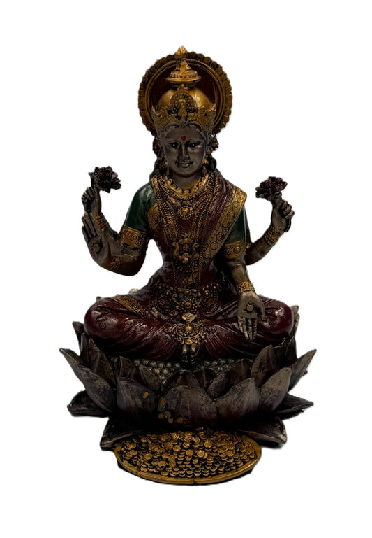 Front view of Lakshmi Hindu goddess statue seated on lotus with gold coins symbolizing wealth and prosperity
