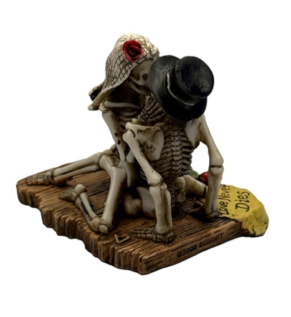 Angled view of skeleton bride and groom statue showing romantic embrace and detailed sculpted bones
