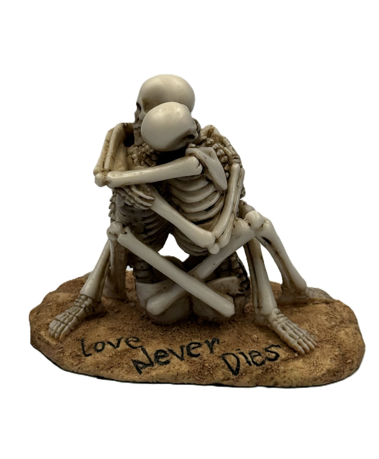 Front view of gothic skeleton couple embracing statue with “Love Never Dies” engraved base
