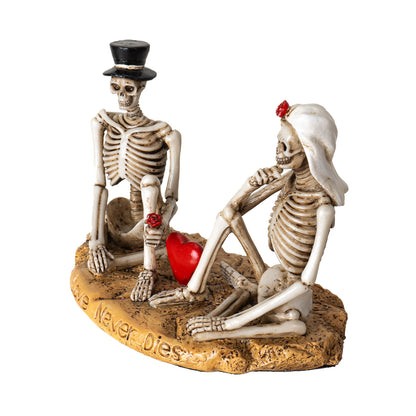 Side view of skeleton lovers statue with relaxed pose and red heart accent
