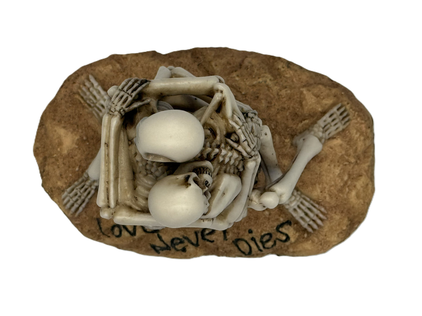Top view of skeleton couple statue showing intertwined pose and textured base with engraved text
