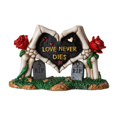 Front view of skeleton hands forming heart statue with love never dies text and red roses
