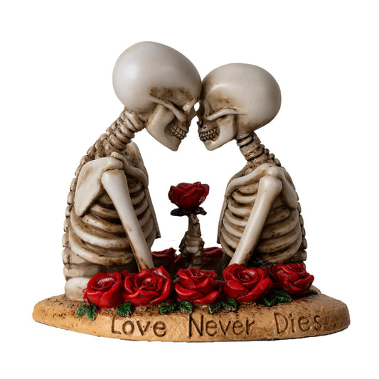 Front view of skeleton lovers statue with red roses and love never dies engraved base
