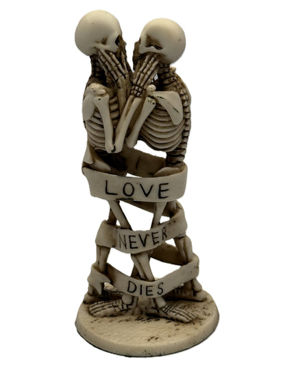 Angled front view of gothic skeleton lovers statue highlighting embrace and sculpted bone details
