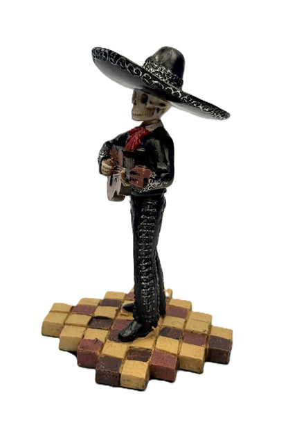 Side view of skeleton mariachi guitar player figurine in black suit with detailed sombrero and guitar
