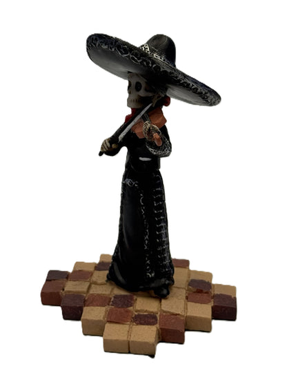 Side view of skeleton mariachi violin player figurine in black dress with detailed sombrero and instrument
